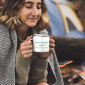 mockup-featuring-a-short-haired-woman-at-a-camping-site-holding-a-12-oz-enamel-mug-with-a-silver-rim-30503